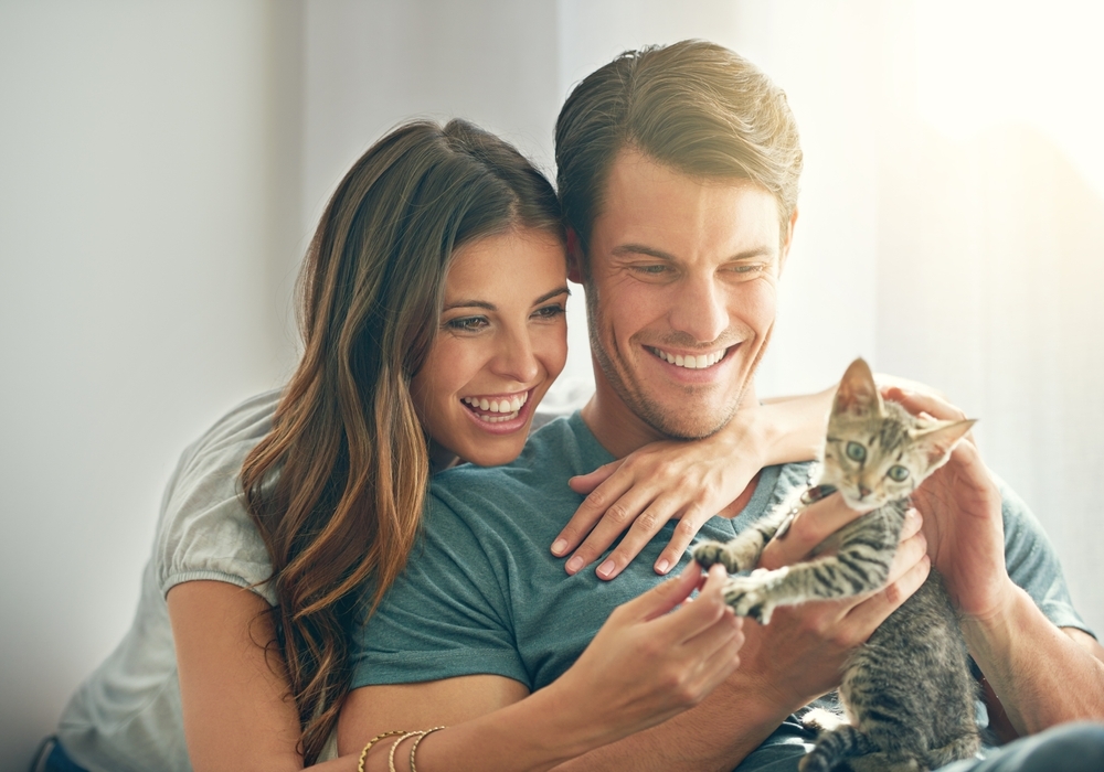 happy family with cat pet spending quality or bonding time in living room