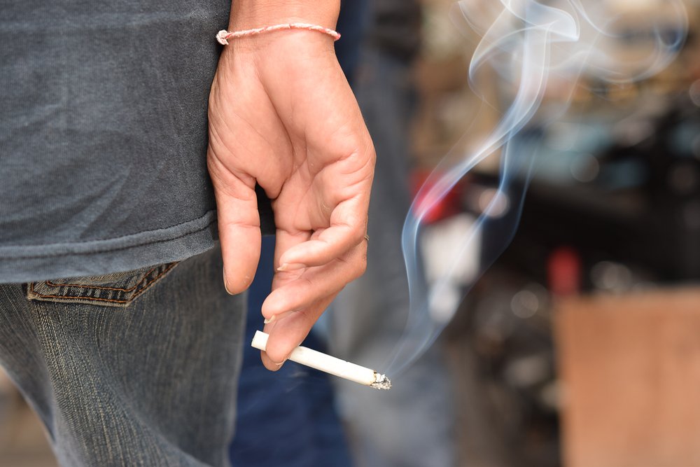 cigarette in man hand with smoke