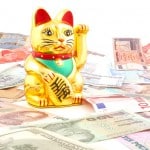 A Maneki Neko, or lucky cat, surrounded by money.