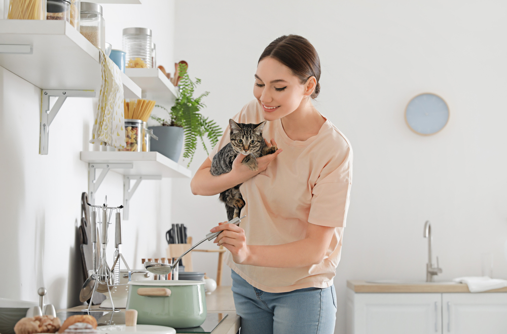 Woman with cat cooking in the kitchen