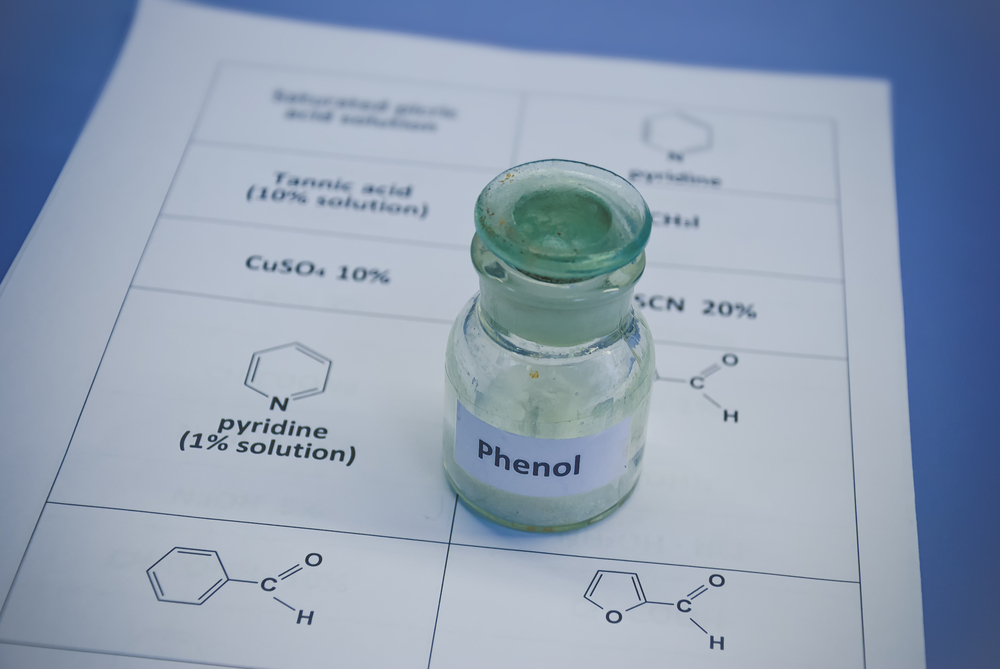 Phenol in old glass bottle on a sheet of paper with chemical formulae