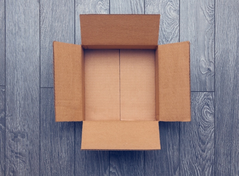 empty open cardboard box on wooden surface