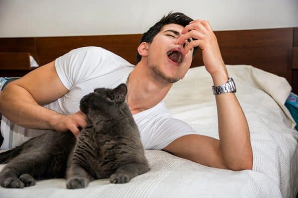 Man with cat allergies sneezing.