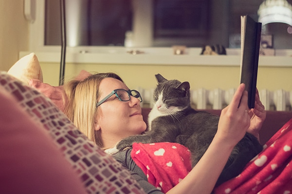 A cat sleeping on a woman's chest.