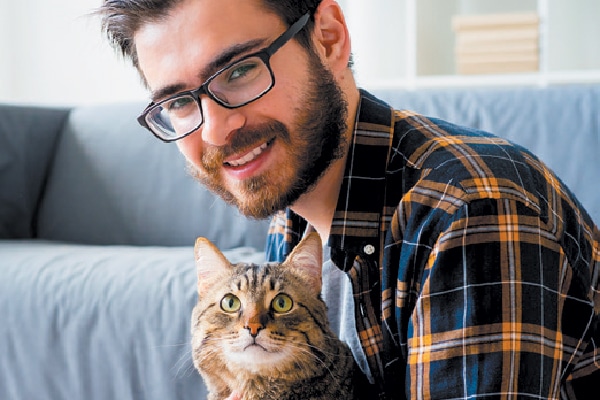 Professional man or guy with glasses holding a cat.