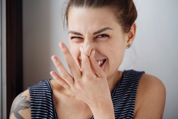 A woman holding her nose like it smells.