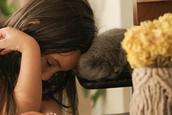 a little girl that is laying down next to a cat