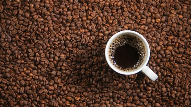 Cup of black coffee with beans