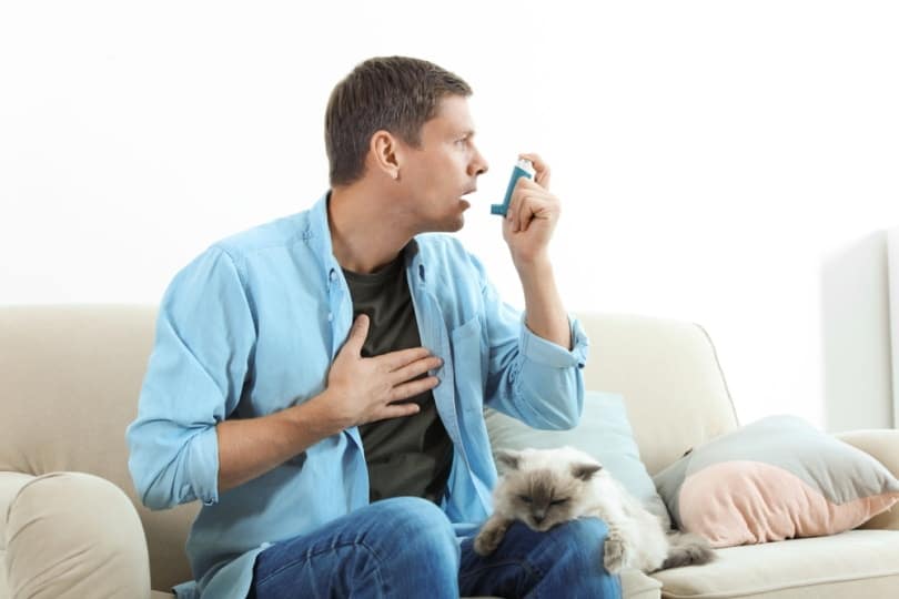 Man using asthma inhaler