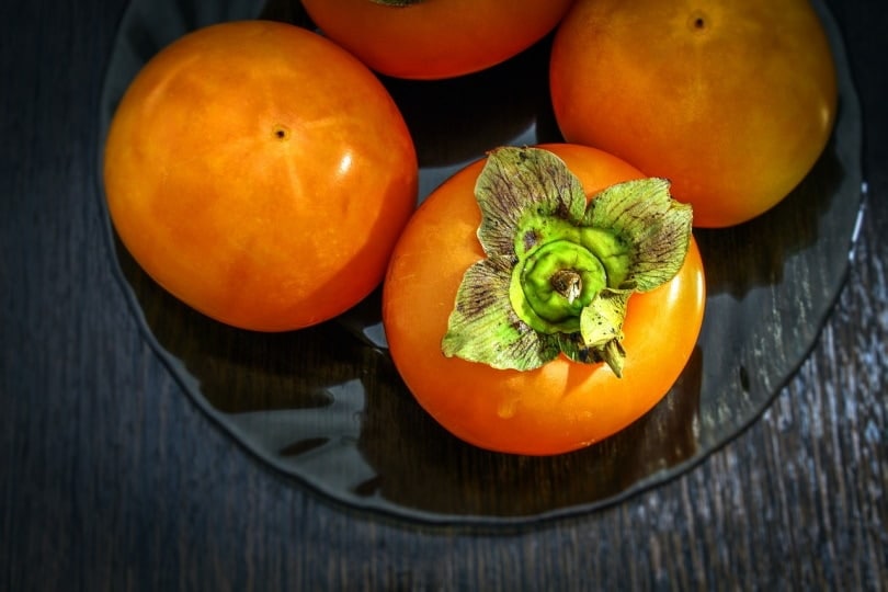 Persimmon fruits on a glass plate
