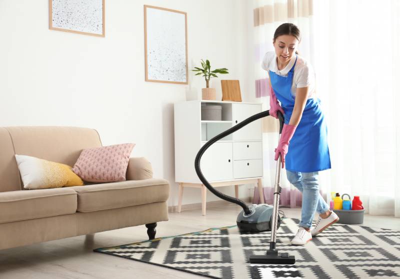 Woman hoovering carpet in living