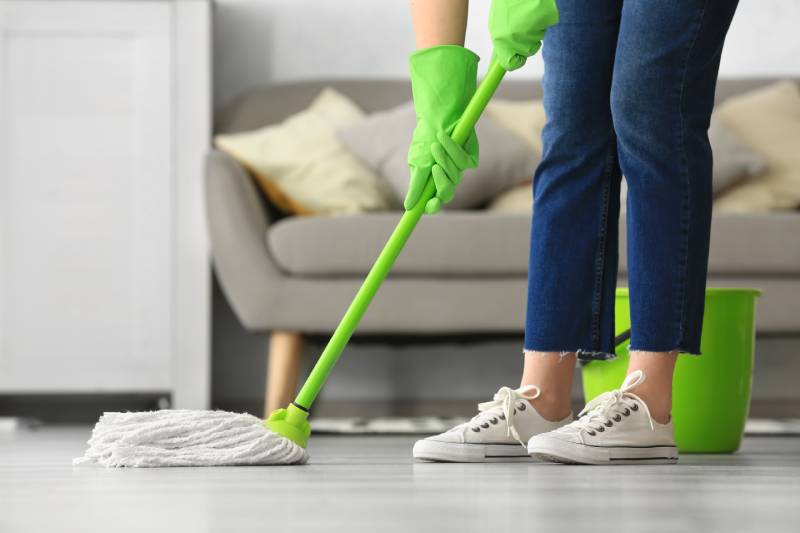 Woman mopping floor in room