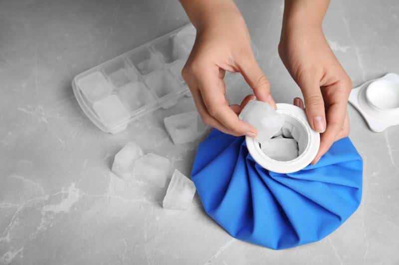 Woman putting ice cubes into pack