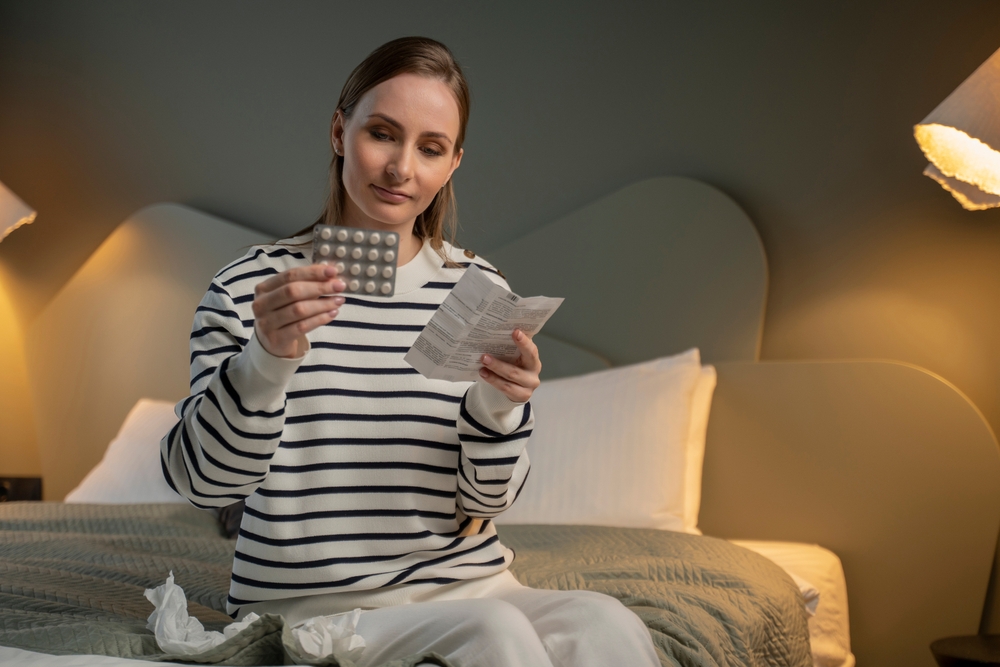 Woman reading medicine leaflet before taking pills