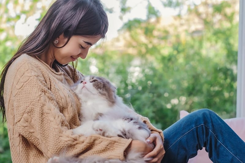a woman holding a cat on her lap