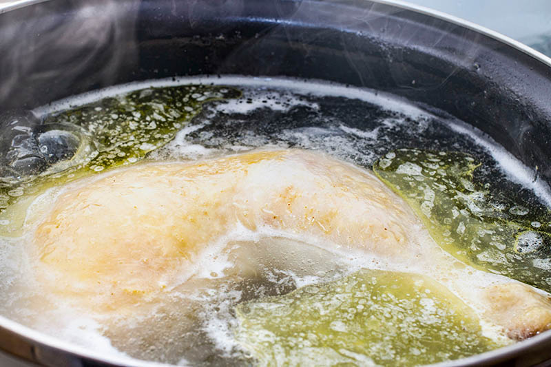 boiled chicken in a pot broth close-up