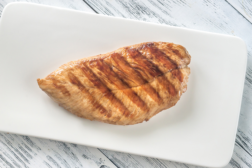 Grilled turkey breast on white plate
