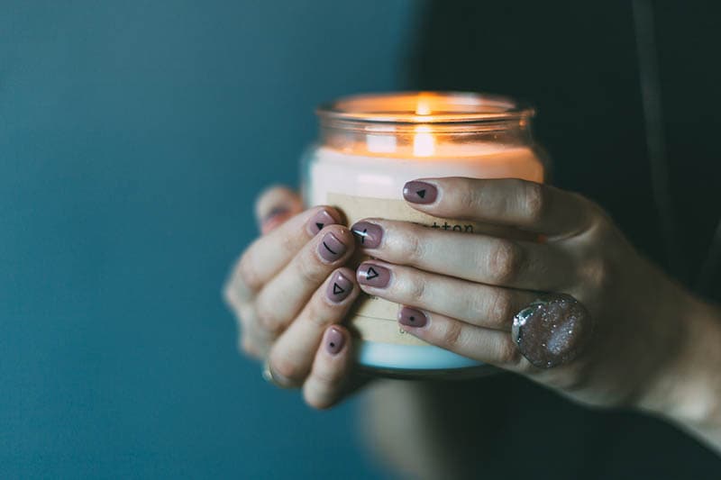 hand holding a scented candle