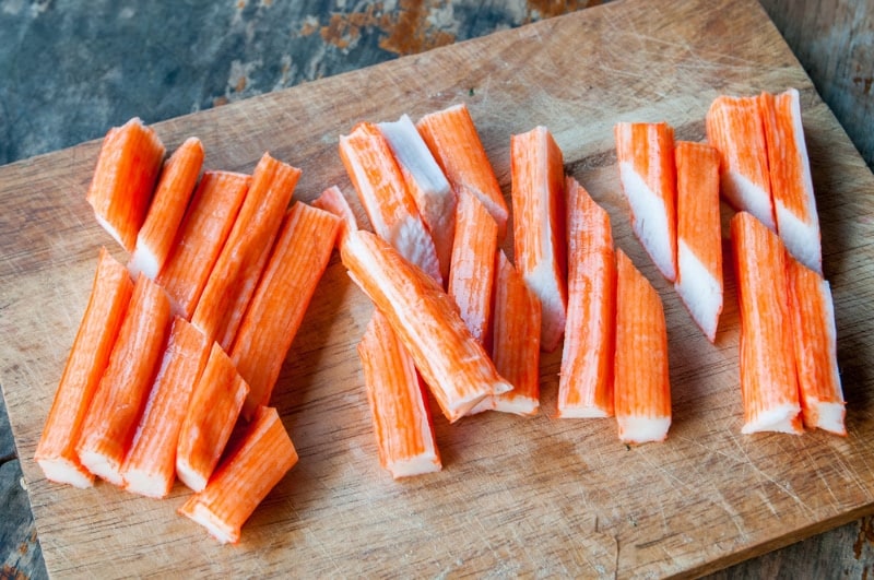 imitation crab sticks on wooden board