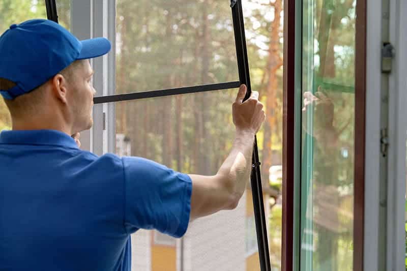man installing window screen