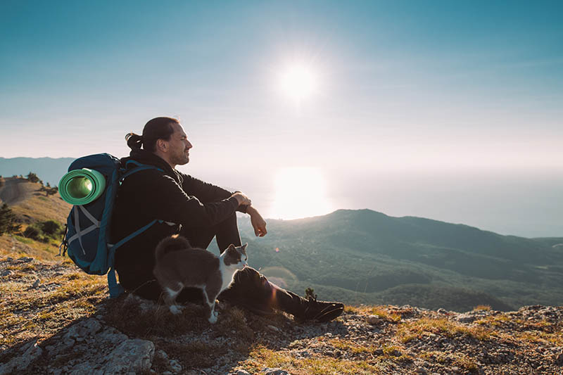 man went hiking with a cat