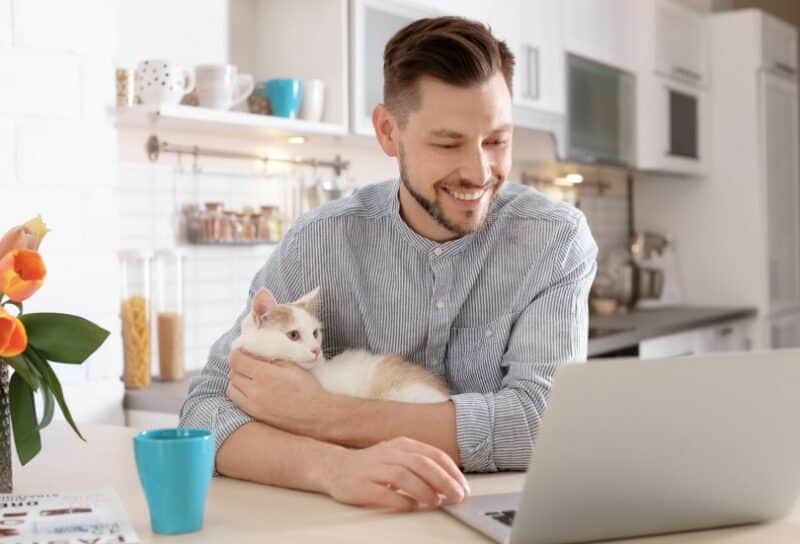 man with cat and laptop