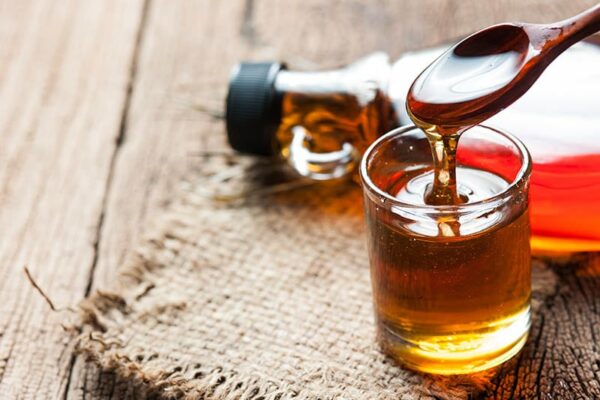 maple syrup in glass bottle on wooden table