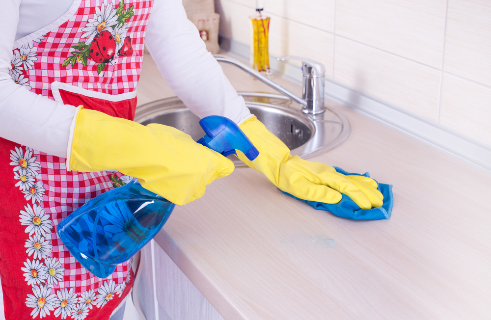 woman cleaning kitchen countertop