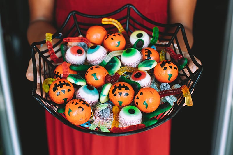 woman holding a basket of halloween candies