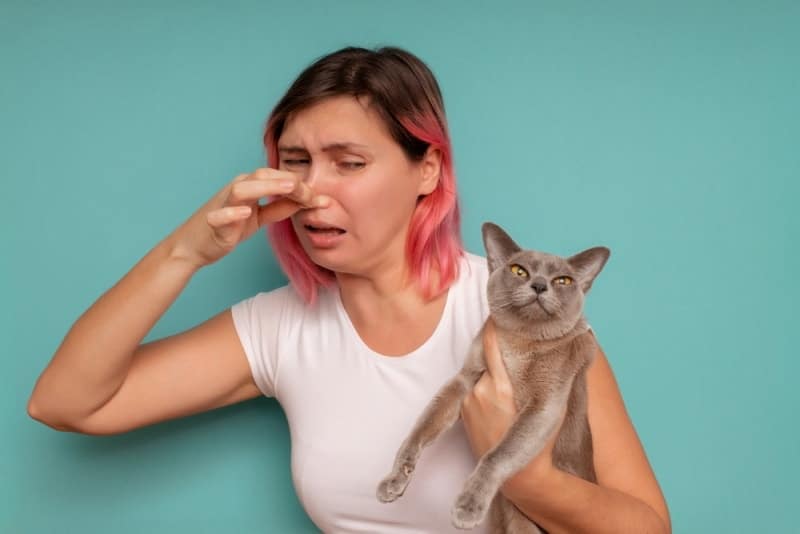 man holding cat with bad smell