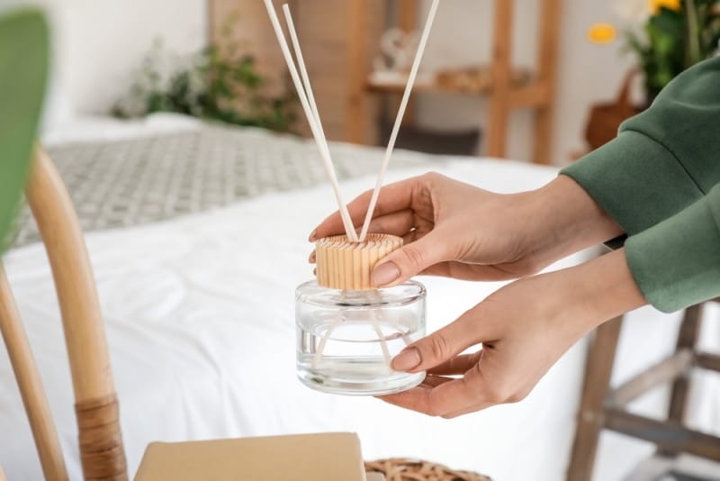 woman holding reed diffuser