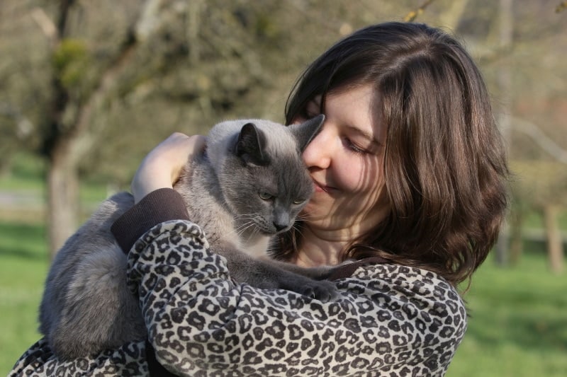 woman hug her siamese cat