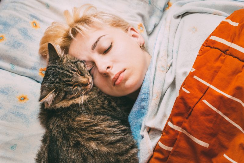 woman-sleeping-with-her-cat