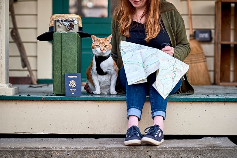 woman with a map travelling with a cat