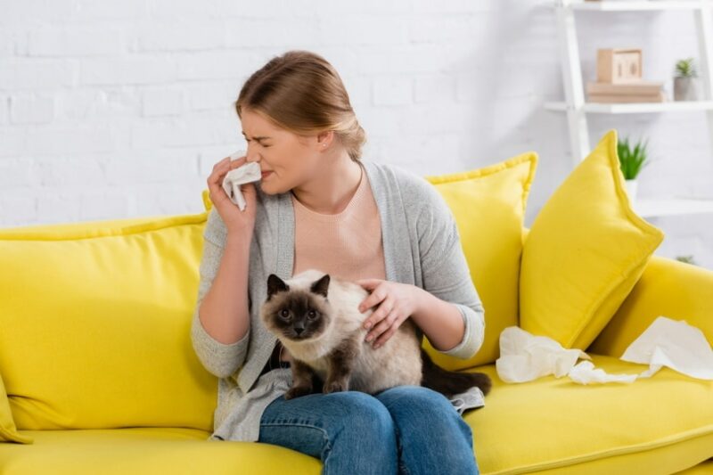 woman with allergy holding cat