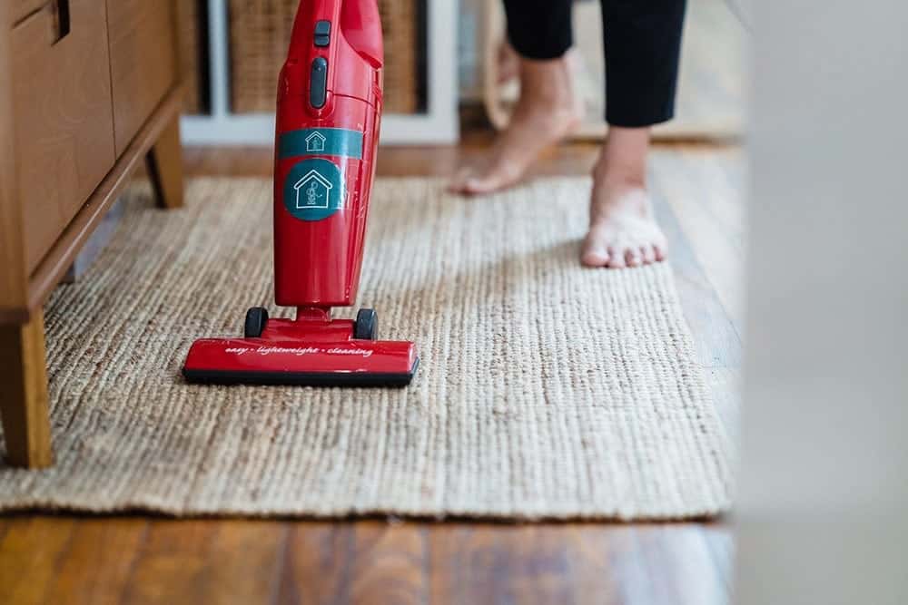 A Person Vacuuming a Carpet