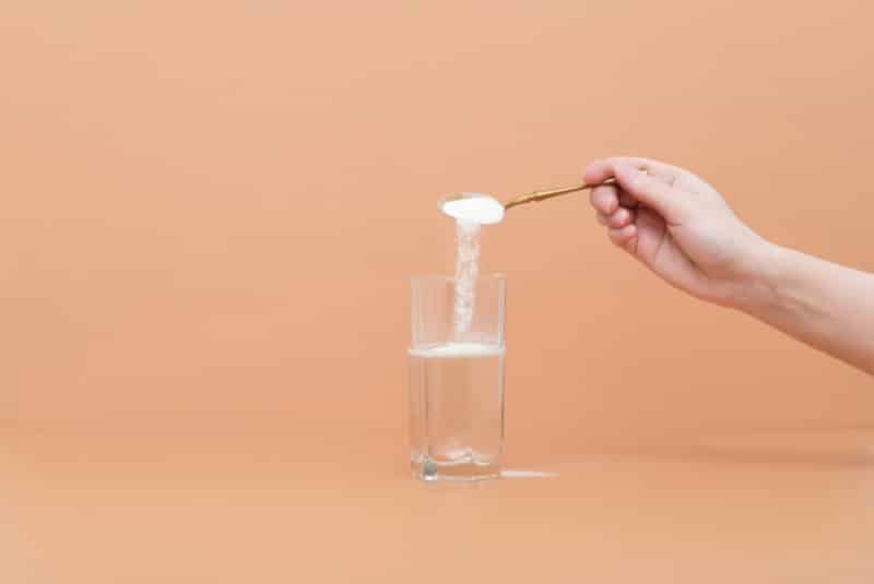 Additive being poured into glass of water