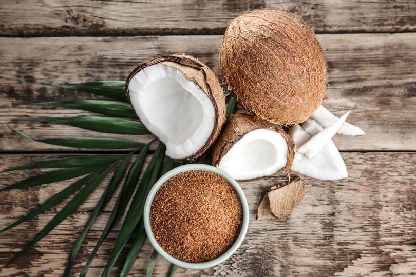 Bowl of brown sugar and coconut on wooden background