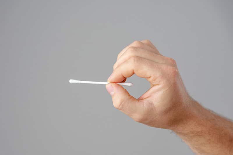 Cotton swabs are held in the hand