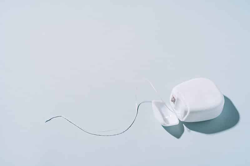 Dental floss in a white box on a blue background