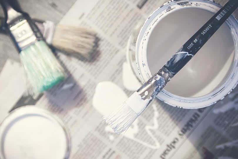 a can of paint and brushes