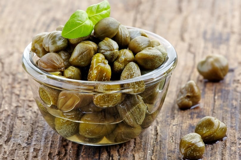 bowl of capers in wooden table