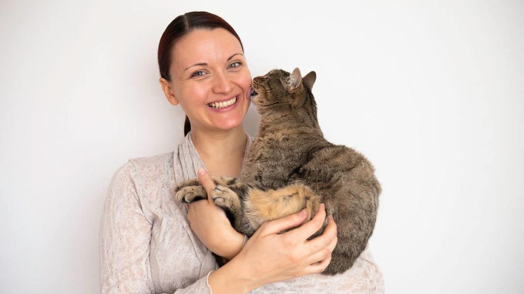 cat licking a woman