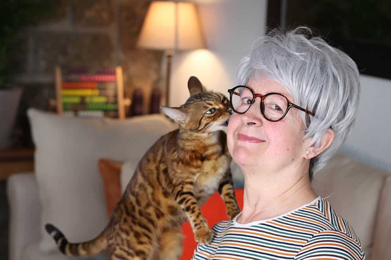 Cat licking woman's ear