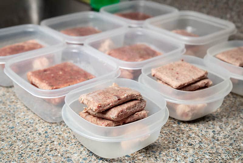 dividing homemade cat food on separate containers for refrigeration