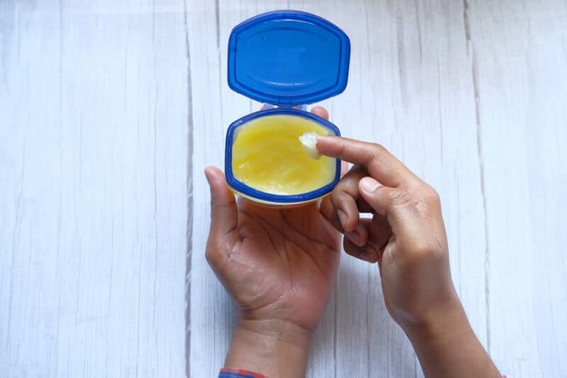 high angle view of man hand use white petroleum jelly