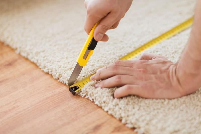 male hands cutting the carpet