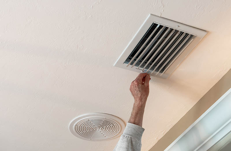 man adjusting air vent