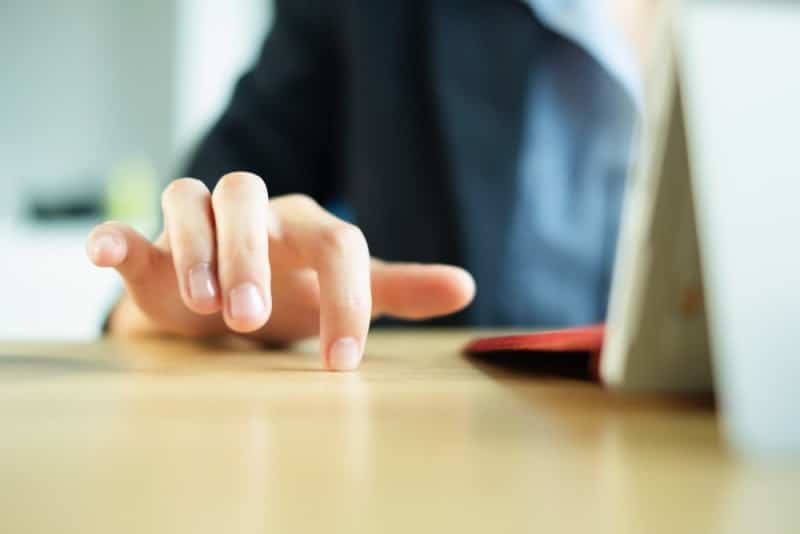 man's finger on wooden table