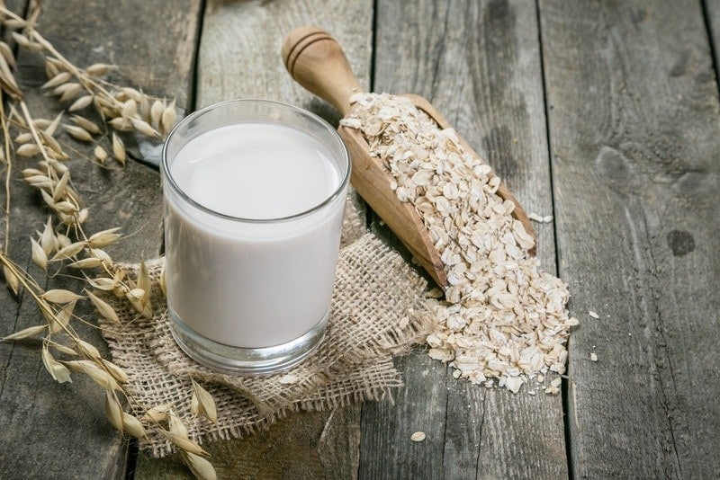 oat milk in a glass on wooden table
